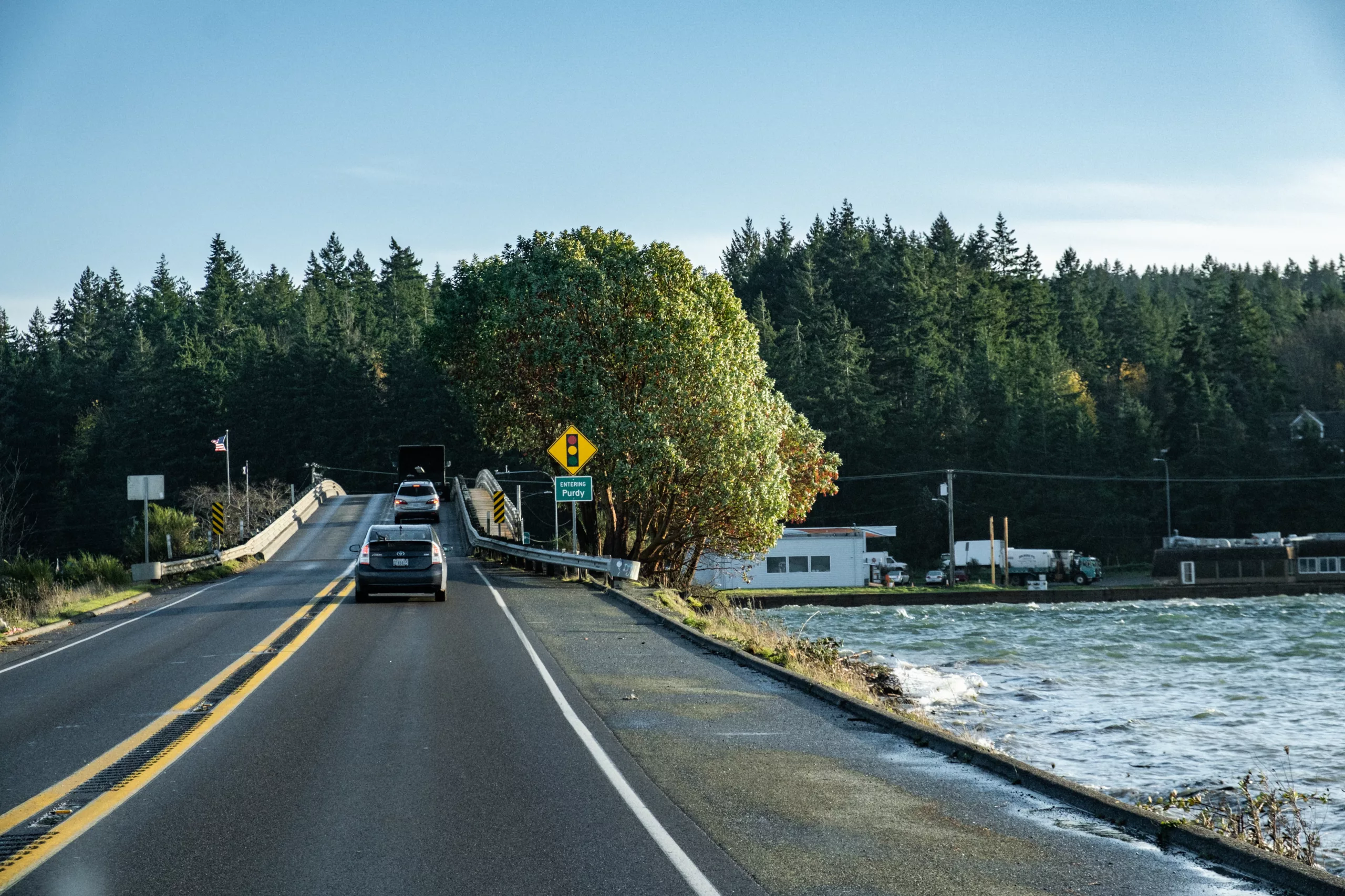 A Bridge with the green Entering Purdy sign alongside of the bay Purdy, WA
